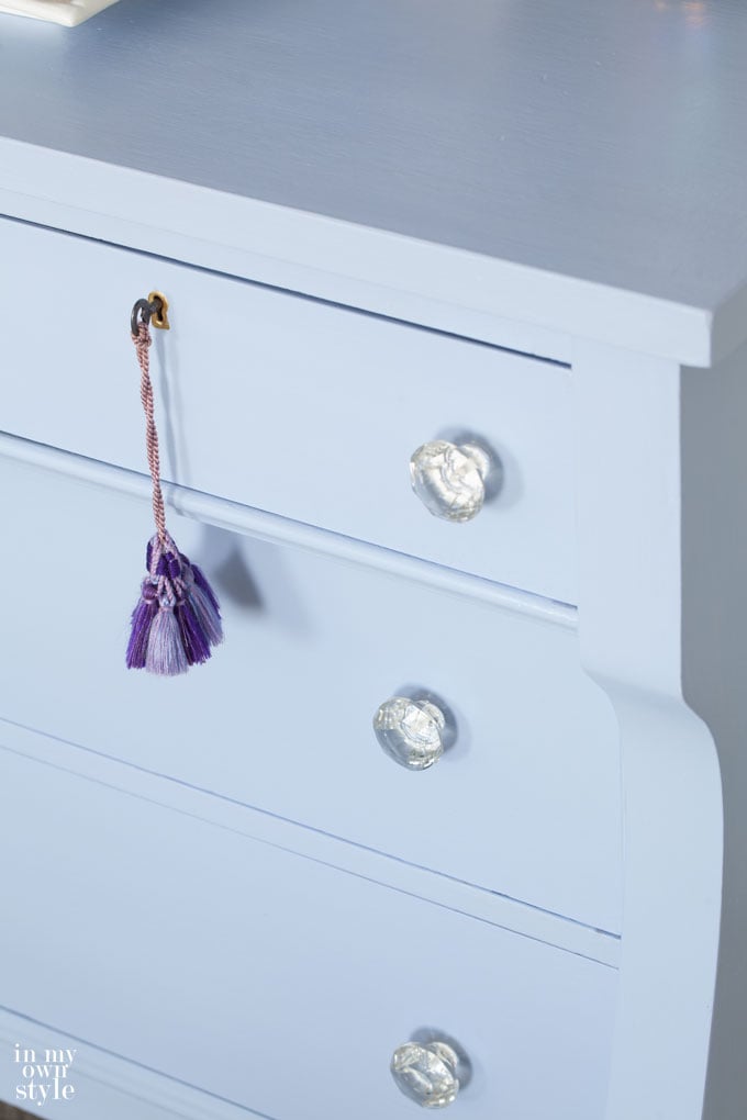 The best way to paint furniture like this blue dresser with glass drawer knobs.