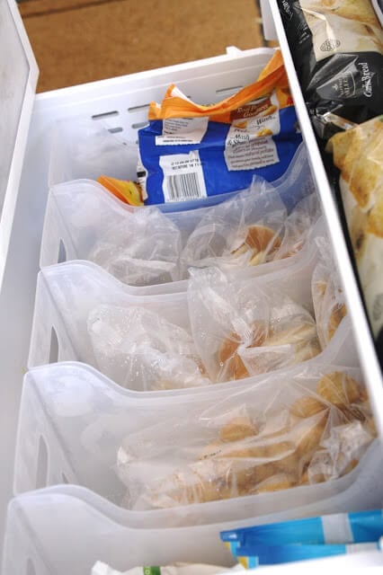 Using multi-use bins to organize a freezer drawer.