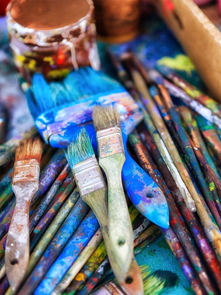 a pile of used paint brushes on a table