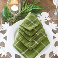 Green napkin folded in the shape of a Christmas tree