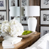 Console table with a trio of large wall mirrors behind it. The table is decorated with white and green.