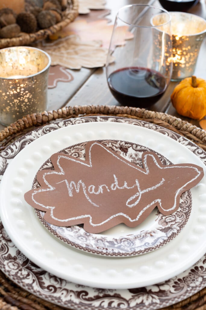 brown paper oak leaf place card on top of a dinner plate on a table