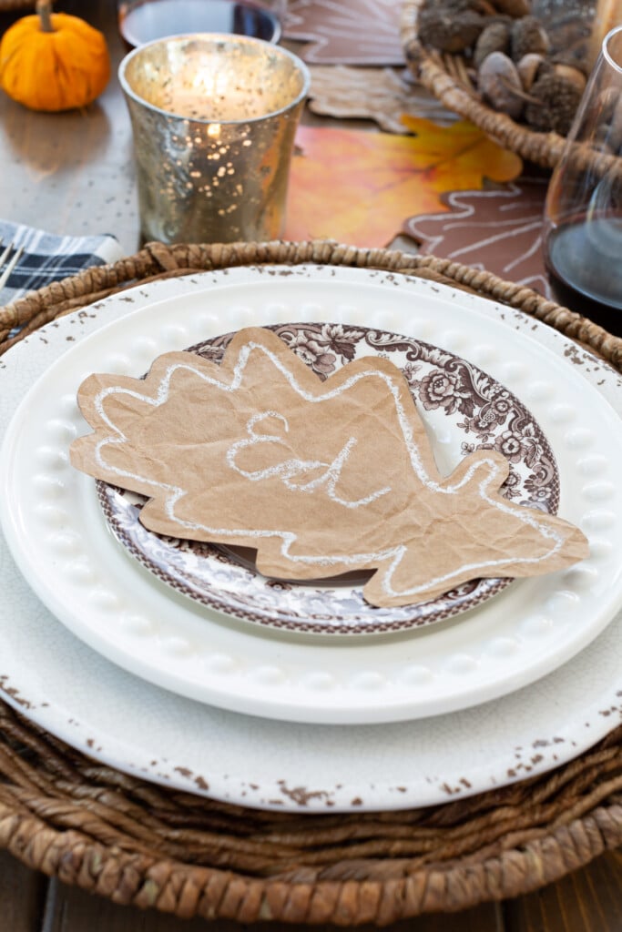 paper oak leaf place card on top of a dinner plate on a table