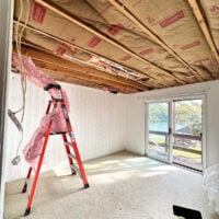 guest room with ceiling removed after a tree went through it.