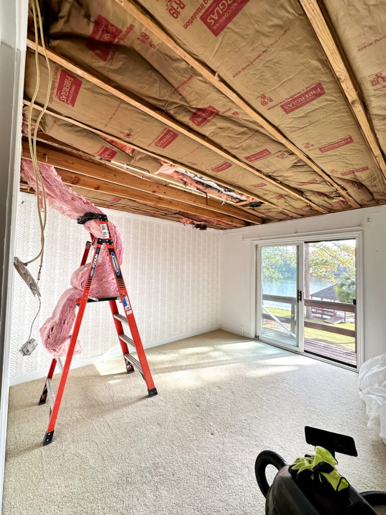 guest room with ceiling removed after a tree went through it.