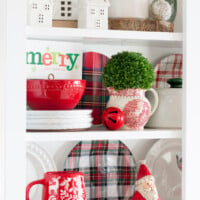 A mix of Christmas decor items styled on open shelves in a kitchen.