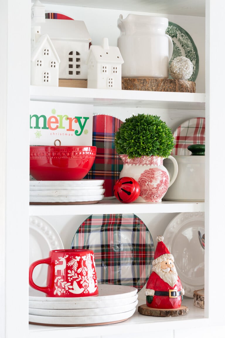 A mix of Christmas decor items styled on open shelves in a kitchen.