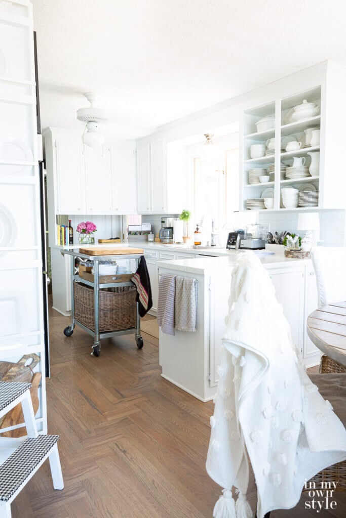 Small white kitchen with driftwood grey wood floors.