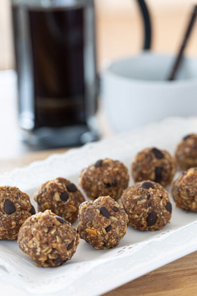 Two rows of healthy energy power balls on white plate.