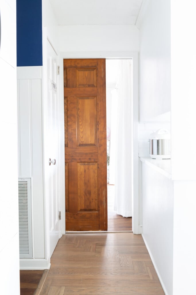 Wood pocket door at entrance to room where one side is being transformed to become a Butler's pantry and kitchen storage area.