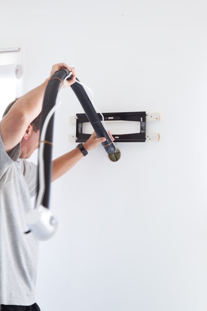 Man placing kit tube through the holes he drilled.